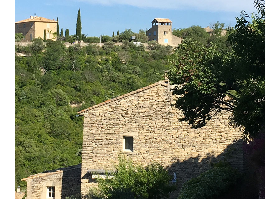 Des maisons de pierre sèche nichées dans la végétation à flanc de colline : tout le charme du Luberon.