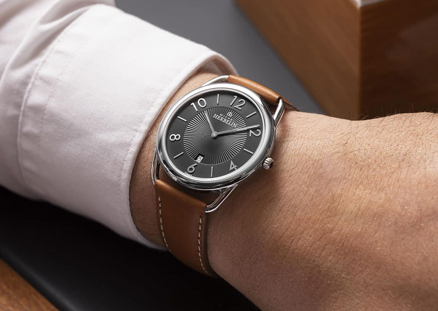 La montre Equinoxe de Michel Herbelin au cadran gris anthracite sur bracelet cuir gold