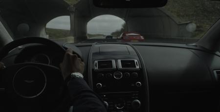 Interior picture of an Aston Martin and a Jaeger Lecoultre watch on driver's wrist